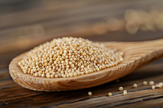 Gluten free amaranth grain in wooden spoon, popped grains isolated on wooden background