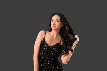 Fototapeta premium Beautiful young woman with dark wavy hair on black background