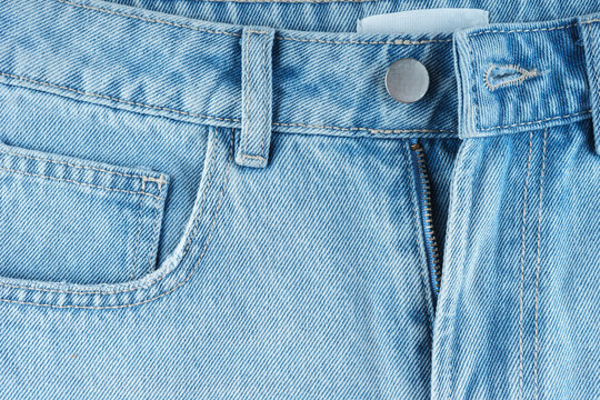 Front side of blue jeans pants pocket, small pocket and metal button close up, macro. Fashion concept, business, shopping, sale. Design detail, button and seams, copy space