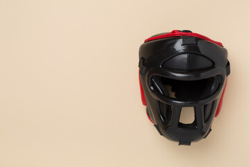 Black leather boxing helmet on color background, top view.