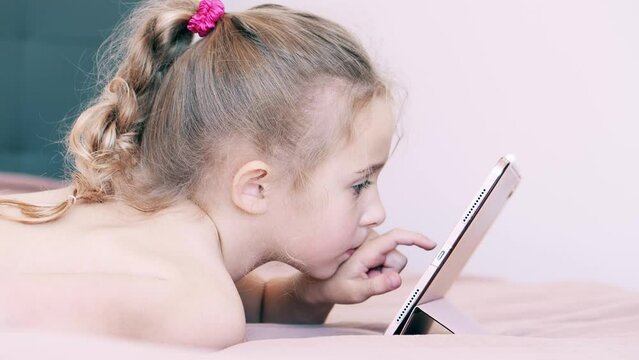 Focused girl uses her tablet computer