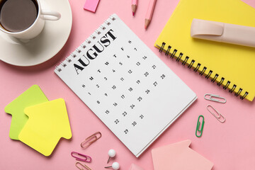 Calendar with cup of coffee and office stationery on pink background