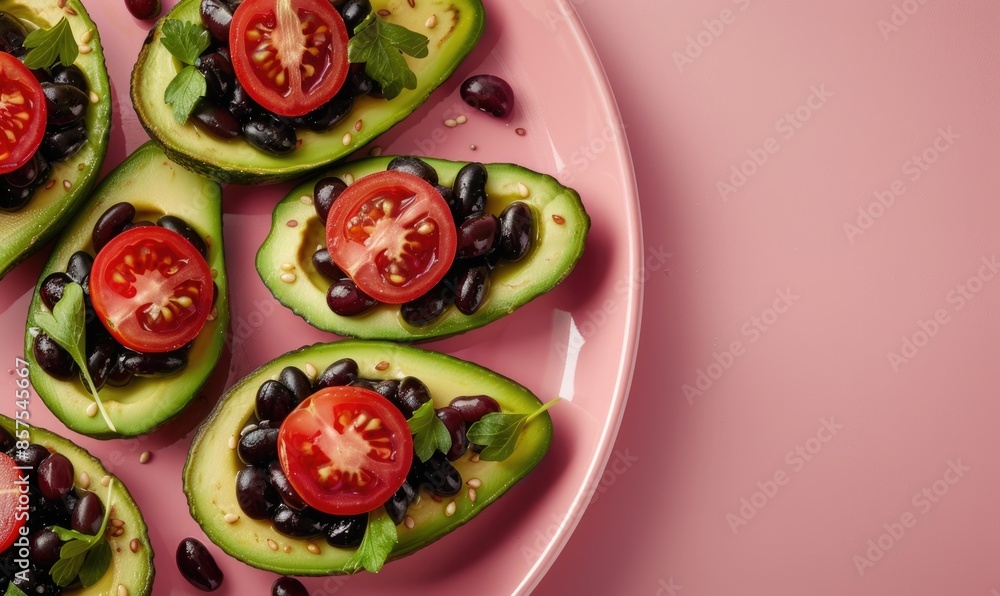 Wall mural Avocado and black bean stuffed cherry tomatoes on a pastel pink plate - Wall murals