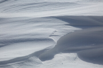 Naklejka premium Fresh White Wintery Wind Blown Snow Drifts Background Image With Highlights and Shadows