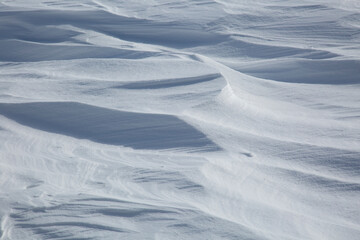 Fresh White Wintery Wind Blown Snow Drifts Background Image With Highlights and Shadows