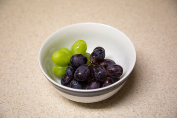 White Bowl of Fresh Green and Red Grapes on the Vine, Washed and Ready to Eat