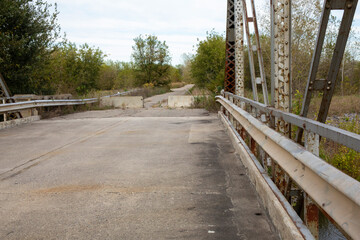 Old Abandoned Metal Bridge Leading to Road Blocked Cement Barrier Railing Infastructure Rural Old Road