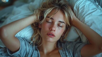 Fototapeta premium Blonde woman with eyes closed rests on a bed, exuding calm and relaxation, in a soft and peaceful bedroom setting that highlights tranquility and comfort.