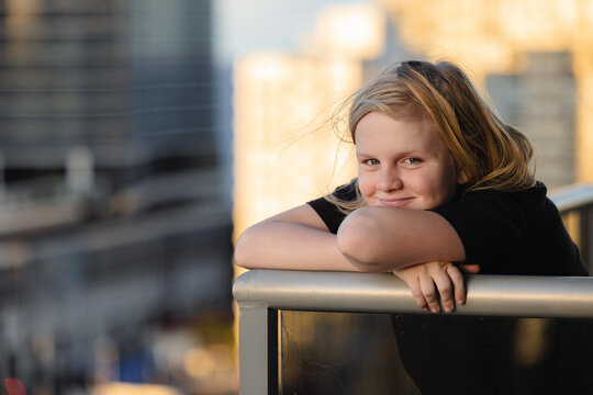 Pre-teen boy standing on balcony of high rise building on the Gold Coast with view of Surfers Paradi