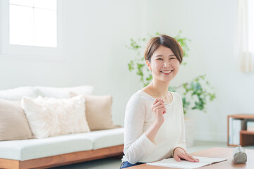 家で勉強する社会人女性（カメラ目線）