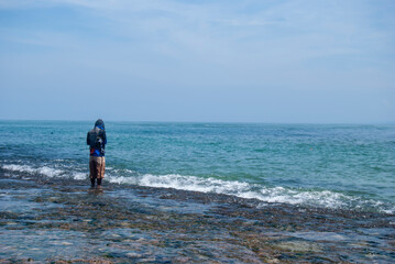 someone is fishing on the beach using a simple tool