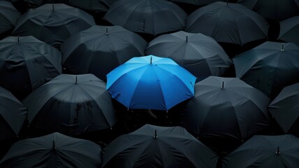 Blue umbrella in a sea of black umbrellas, rainy day, urban setting,