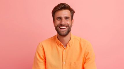 Obraz premium Smiling man in orange shirt against pink background.