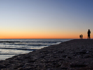 couple walking on the beach at sunset