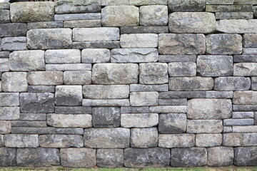 Aged and weathered stone brick wall background texture with a rugged and rustic appearance
