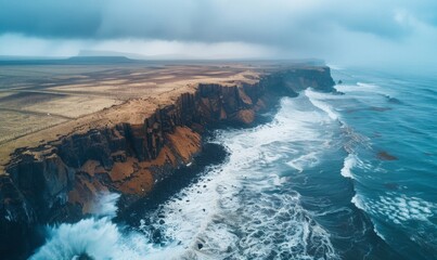 Naklejka premium A coastal area showing severe erosion, with cliffs crumbling into the sea and waves crashing against the remaining land