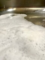 thick soap suds in the kitchen sink