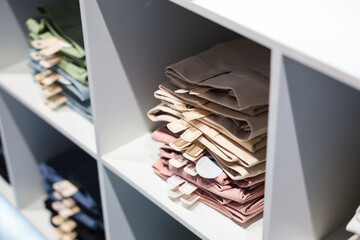 Multi-colored pants stack on shelves For Sale In Store.