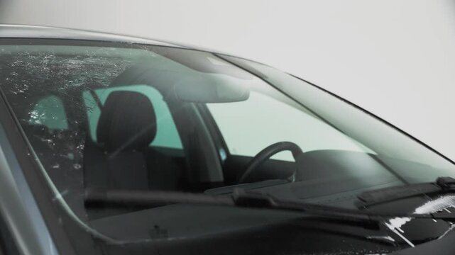 Windscreen wiper fluid being squirted on the windscreen and wiped clean by the windscreen wipers