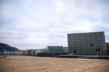 Fototapeta premium Kursaal building along side of old buildings and the beach of Zurriola 
