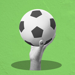 A human hand holding a soccer ball