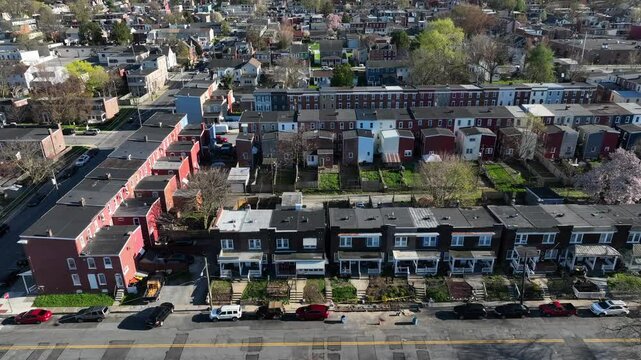 Row of houses in american neighborhood during sunny day in Spring. Homes and buildings in small town. Aerial lateral shot.