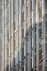 Close-up of the exterior facade of a newly renovated skyscraper, showcasing modern architectural details and glass windows reflecting the sky