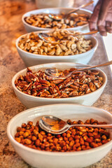 peanuts, cashew nuts, almonds, walnuts, variation in bowls on a marble table