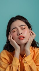 Young woman in a yellow shirt with closed eyes