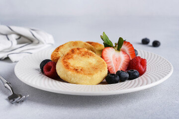 Cheese pancake with strawberries on a light background for breakfast