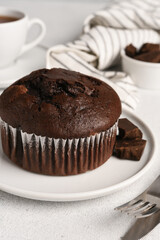 Chocolate muffin with a cup of coffee on a light background