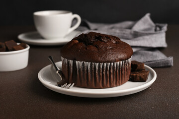 Chocolate muffin on a dark background with a cup of tea.Brownie cupcake