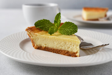 Slice of New York cheesecake on a concrete Light background
