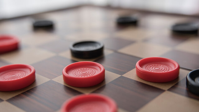 checkers game pieces on the board. Red and black pieces
