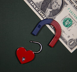 The heart-shaped lock is attracted by a magnet on the dollar. Symbol of fake love or feelings.