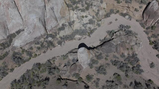 Aerial ped down focus on rocks with reveal of Mount Whitney, California on a summer morning.
