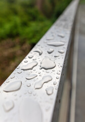 Drops of water from rain on a metal railing