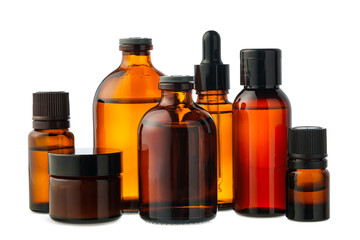 Amber Glass Bottles of Essential Oils and Cream Isolated on White Background