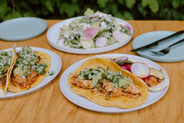 Tacos with fresh salad served on a wooden table outdoors