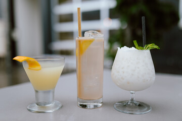 Three assorted cocktails on a table with different garnishes