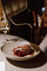 Gourmet dessert with chocolate sauce being poured over it in Amsterdam