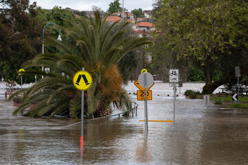 Flooded street with road signs after Maribyrnong River floods