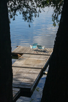 Empty dock with two striped chairs and fishing rods on Lake Sach