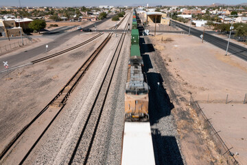 Naklejka premium Overhead view of train in motion in southwestern small town