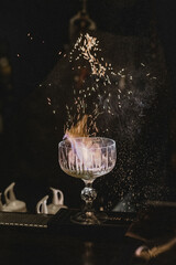 Flaming whiskey cocktail with sparks in crystal rocks glass