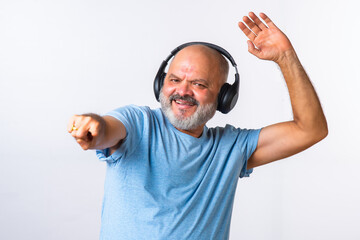 Senior elderly retired Indian asian man wears headphone and listening to music and dancing on beats...