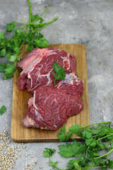 Daging sapi mentah or raw beef on preparation for cooking with some spice. Beef on Eco friendly package and chopping board with wooden rustic background.