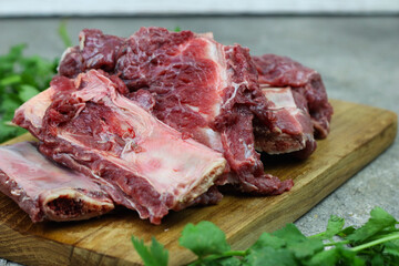 Iga sapi mentah or raw beef ribs  on preparation for cooking with some spice. Beef ribs on chopping board with wooden rustic background.
