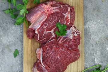 Daging sapi mentah or raw beef on preparation for cooking with some spice. Beef on Eco friendly package and chopping board with wooden rustic background.
