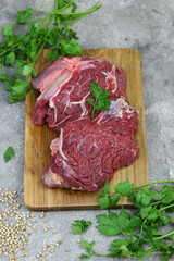 Daging sapi mentah or raw beef on preparation for cooking with some spice. Beef on Eco friendly package and chopping board with wooden rustic background.